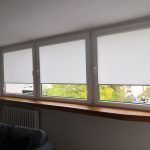 Białe rolety materiałowe 3 okna